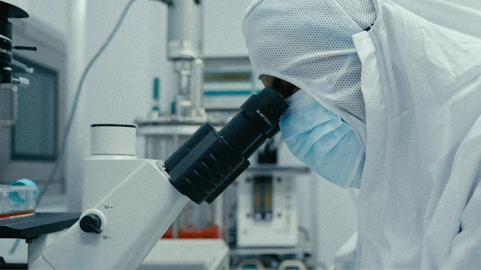 A scientist examining samples through a microscope